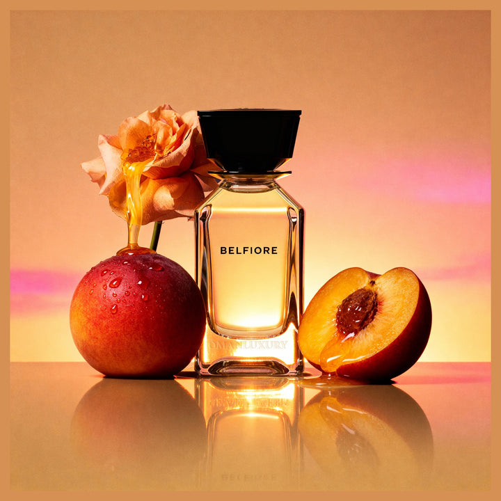 Oman Luxury Belfiore Eau de Parfum bottle with peaches and roses in warm sunset light