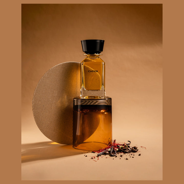 Oman Luxury Caden Eau de Parfum bottle against a stone disc with scattered spice