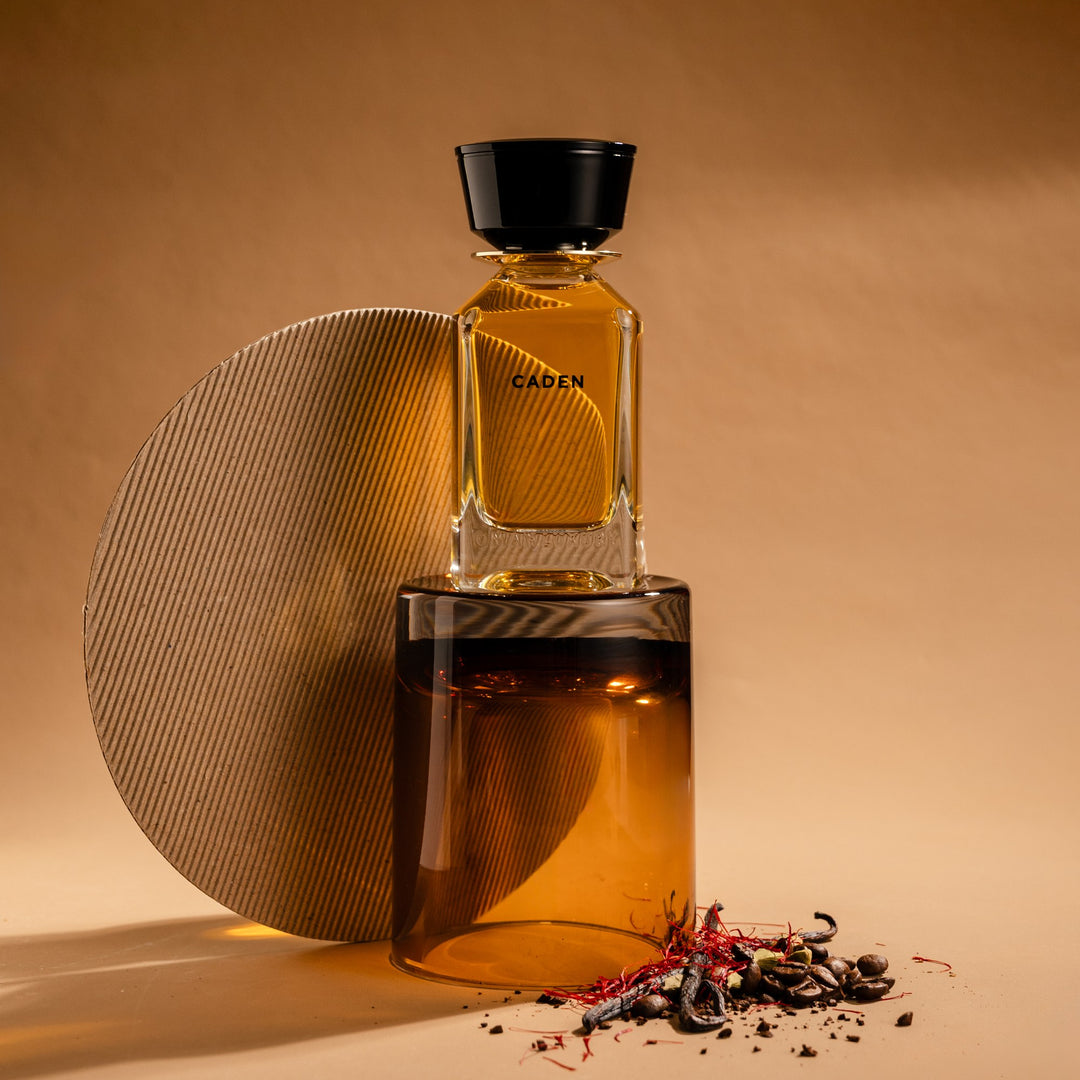 Oman Luxury Caden Eau de Parfum bottle against a stone disc with scattered spice