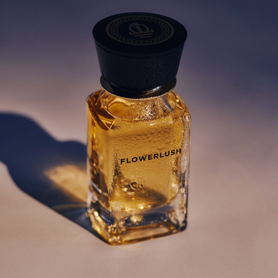 Oman Luxury Flowerlush Eau de Parfum bottle in low golden sun against a dusk blue backdrop