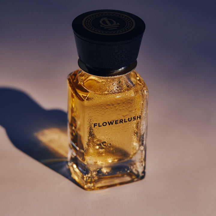 Oman Luxury Flowerlush Eau de Parfum bottle in low golden sun against a dusk blue backdrop