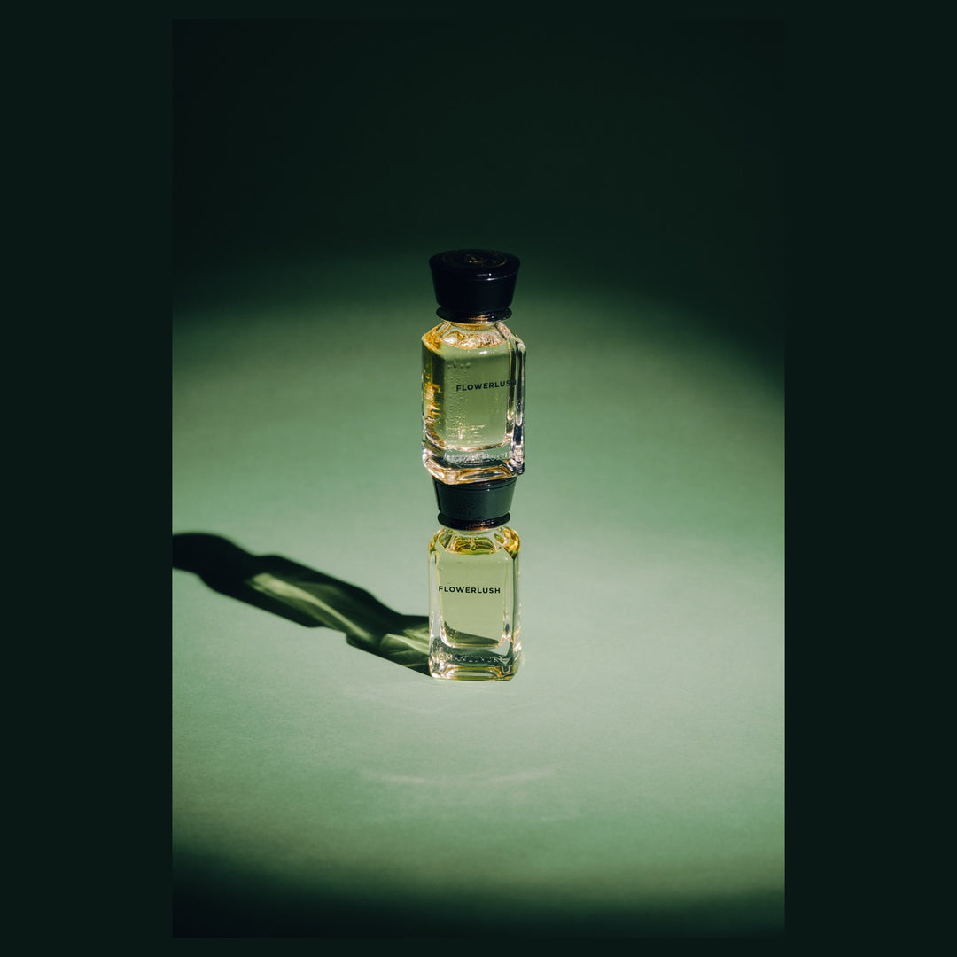 Oman Luxury Flowerlush Eau de Parfum bottle against a deep green studio backdrop