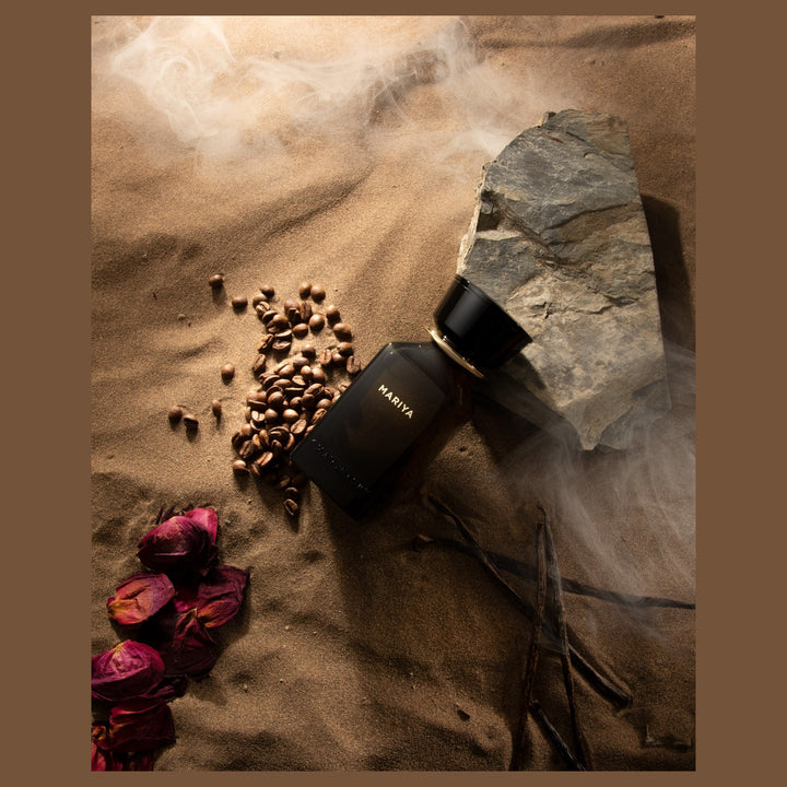 Oman Luxury Mariya Eau de Parfum bottle on sand with rose petals and coffee beans
