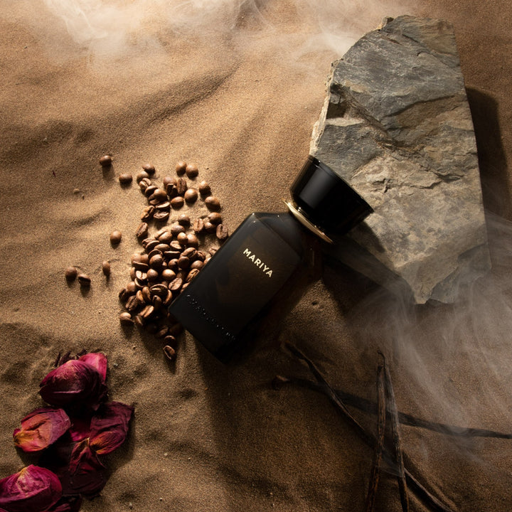Oman Luxury Mariya Eau de Parfum bottle on sand with rose petals and coffee beans