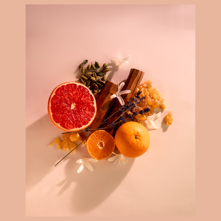 Oman Luxury Nasaj Eau de Parfum bottle flat lay of grapefruit, cinnamon and blossom