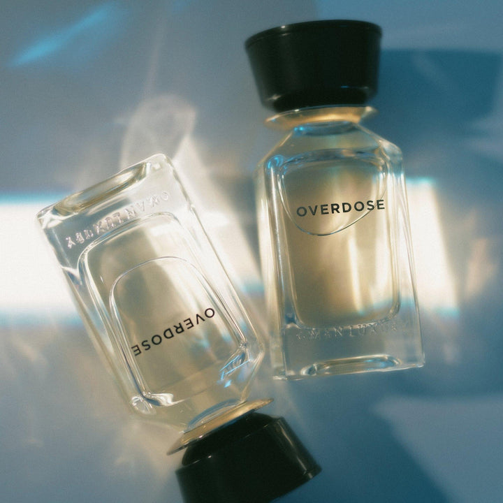 Oman Luxury Overdose Eau de Parfum bottle two bottles crossed in rippling teal light
