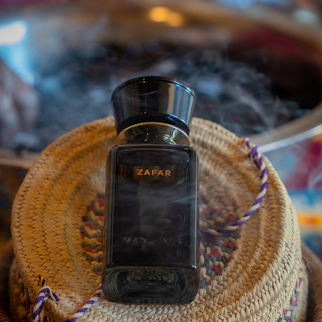 Oman Luxury Zafar Eau de Parfum bottle on a woven Omani basket wrapped in incense smoke